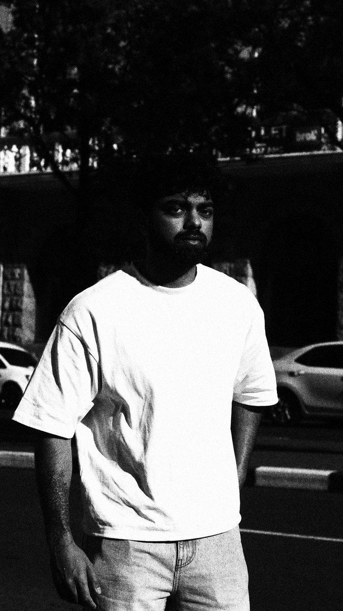 Portrait in a white tee against dark city background